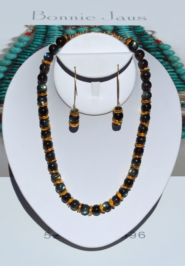 Bonnie Jaus Designs brings you this beautiful necklace and matching earrings. The necklace measures 19.5” and is strung with high-quality, 10.5mm, polished, round, Labradorite beads with gold vermeil spacers in between. It is topped off with small, gold vermeil beads and a hook clasp with a small Labradorite dangle at the back. The earrings hang 2.5” from heavy, gold vermeil wire. They are strung with one of the 10.5mm beads and 2 smaller Labradorite beads separated by gold vermeil spacers. Labradorite is said to stimulate the imagination, develop enthusiasm, and bring clarity to meditation. It was first found in 1770 on the Labrador Peninsula in Canada; thus, its name. It is also found in Norway and Russia.